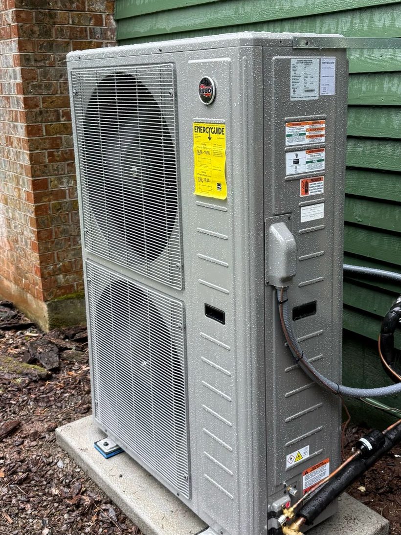 Ruud heat pump condenser installed on a level pad beside a Canby, Oregon home